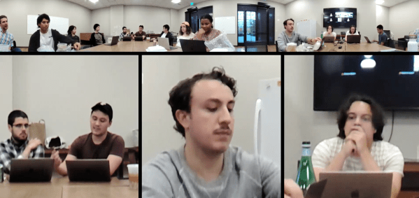 A zoom screenshot with some students in one room at a conference table.
